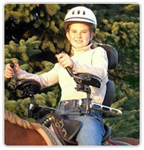 A girl riding a horse with Rifton Pacer arm prompts attached to the saddle.