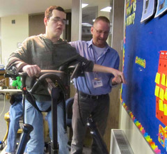 A TBI patient is successfully able to step consistently in a TRAM device with assistance from his therapist.