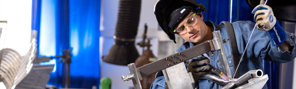 A young man welding a Rifton Equipment product.