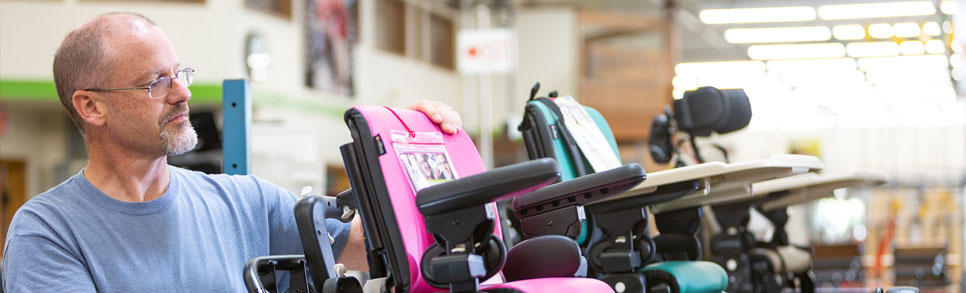 A man inspecting a row of Rifton Activity Chairs.