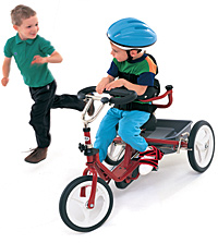 A boy riding a red Rifton Adaptive Tricycle.