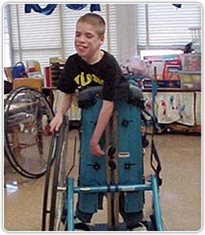 A boy standing in a Rifton Mobile Stander.