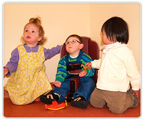 A little boy playing in his Rifton Corner floor sitter.
