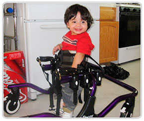 A little boy smiling in his purple Rifton Pacer gait trainer.