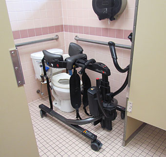 The Rifton TRAM positioned over a toilet is a sit to stand transfer device that is helping patients with cerebral palsy. 
