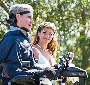 Augie Nieto, a man with ALS, walking his daughter down the aisle at her wedding, aided by the Rifton TRAM.