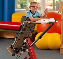 A young boy in a Prone stander gives a wave as he participates in classroom activities. 