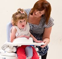 Using recommended guidelines, a therapist properly positions a child with special needs on the Rifton Hygiene Toileting System.