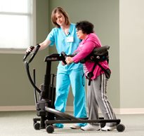A therapist guides a home care patient in a stand-pivot transfer using the Rifton TRAM 