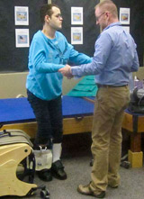 A TBI patient, with the help from his therapist is successfully standing.