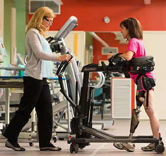 A therapist transfers an amputee using safe patient handling technology