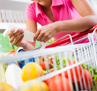 A women rests arms on a shopping cart to more easily push it forward