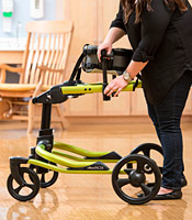 A school therapist lowers the height of the upright posts to position the chest prompts for use.