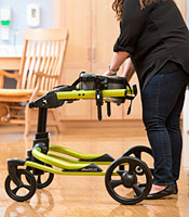 A school therapist adjusts the width and angle of the chest prompt to accommodate a student with disabilities. 