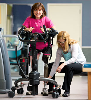 A therapist guides patient ambulation in the Rifton TRAM- a safe patient handling and mobility device.