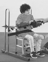 A child being properly positioned in adaptive classroom seating equipment by a teacher