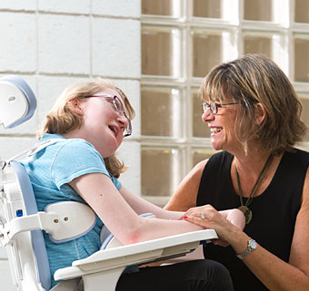 A physical therapist uses the Rifton TRAM for toilet transfers for a student