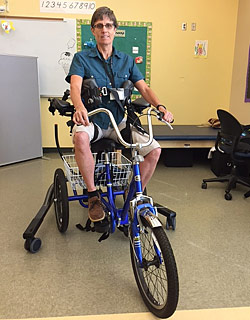 Lowering a special needs student onto a trike using the TRAM so they can exercise