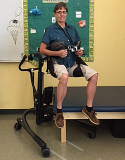 Using trunk supports and leg straps to lift a student and get them ready for physical activities