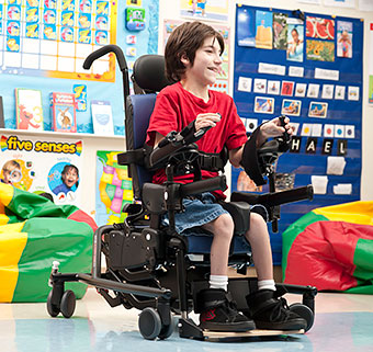student sitting in a Rifton Activity Chair in a classroom