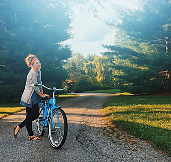 Karlie Pickett stands by her bicycle waiting for her brother with cerebral palsy on his special needs tricycle.