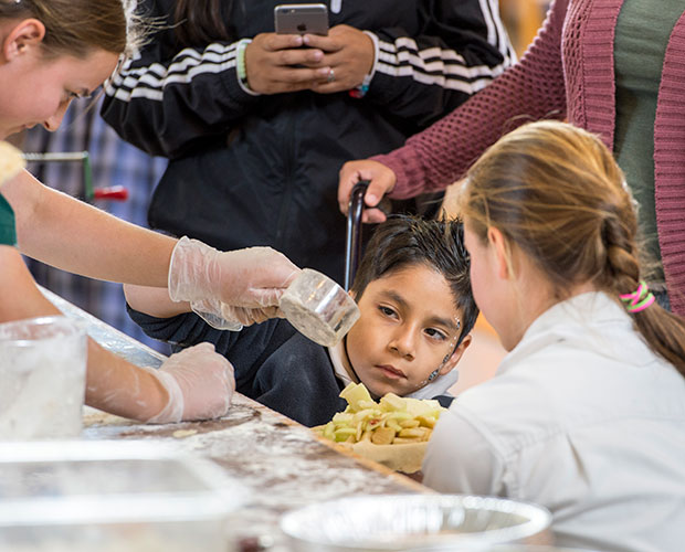 A young boy watches closely as the sugar is measured in his apple pie during Rifton's birthday celebration.