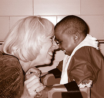 Linda Bidabe smiles as she touches noses with a young boy with disabilities enrolled in the MOVE curriculum.