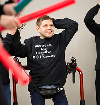 A young man in the MOVE Program at Langan school participates in a dance program in his adaptive equipment.