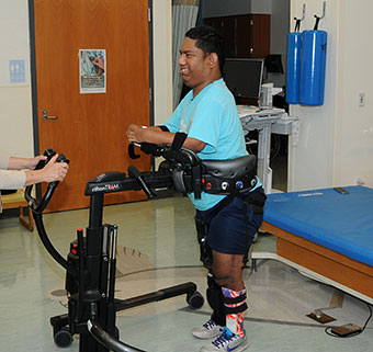 A patient walking successfully in a Rifton TRAM with the aid of a caregiver.