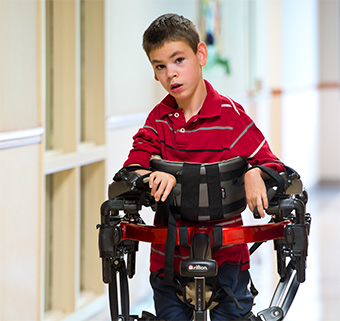 a boy in a Rifton pacer with prompts