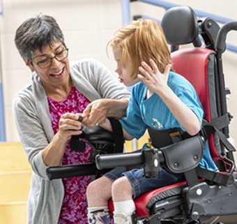 boy sitting on Rifton Activity Chair with caretaker
