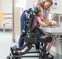 a girl sitting on a Rifton Activity Chair washing her hands