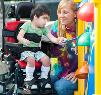 A boy sitting in a Rifton Activity Chair with a forward-leaning tilt