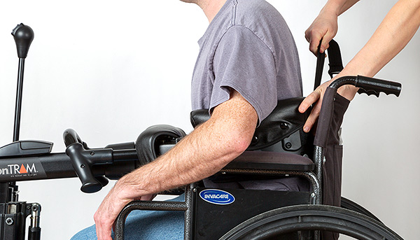A man being transferred out of a wheelchair with a Rifton TRAM