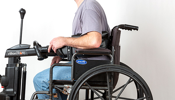 A man being transferred out of a wheelchair with a Rifton TRAM