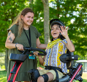 Child having fun in a gait trainer interacting with a caregiver