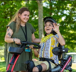 Child having fun in a gait trainer interacting with a caregiver