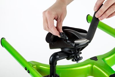 A close up of a hand adjusting the hand grip on a green Rifton Pacer gait trainer.