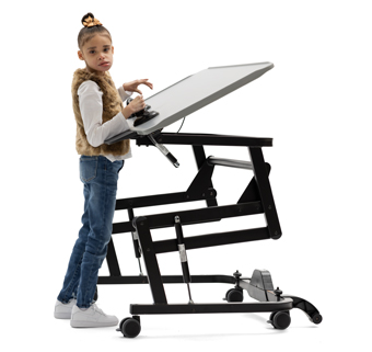 A girl stands at a Rifton Adaptive Desk and holds onto a Rifton Grab Bar.