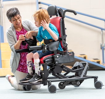 A young man using a forearm support on a Rifton Activity Chair.