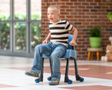 A boy sits on a Rifton Compass Chair.