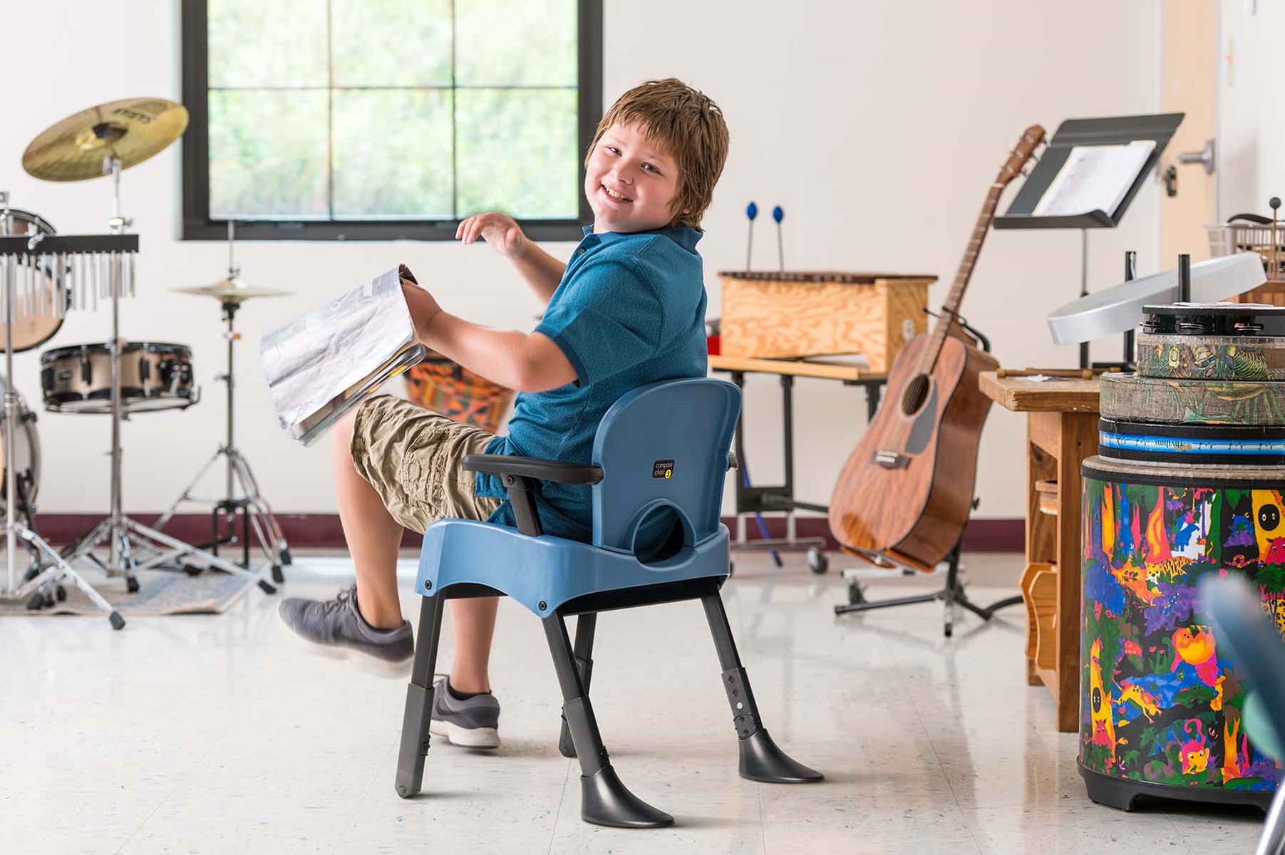 A boy sitting in a Rifton Compass Chair