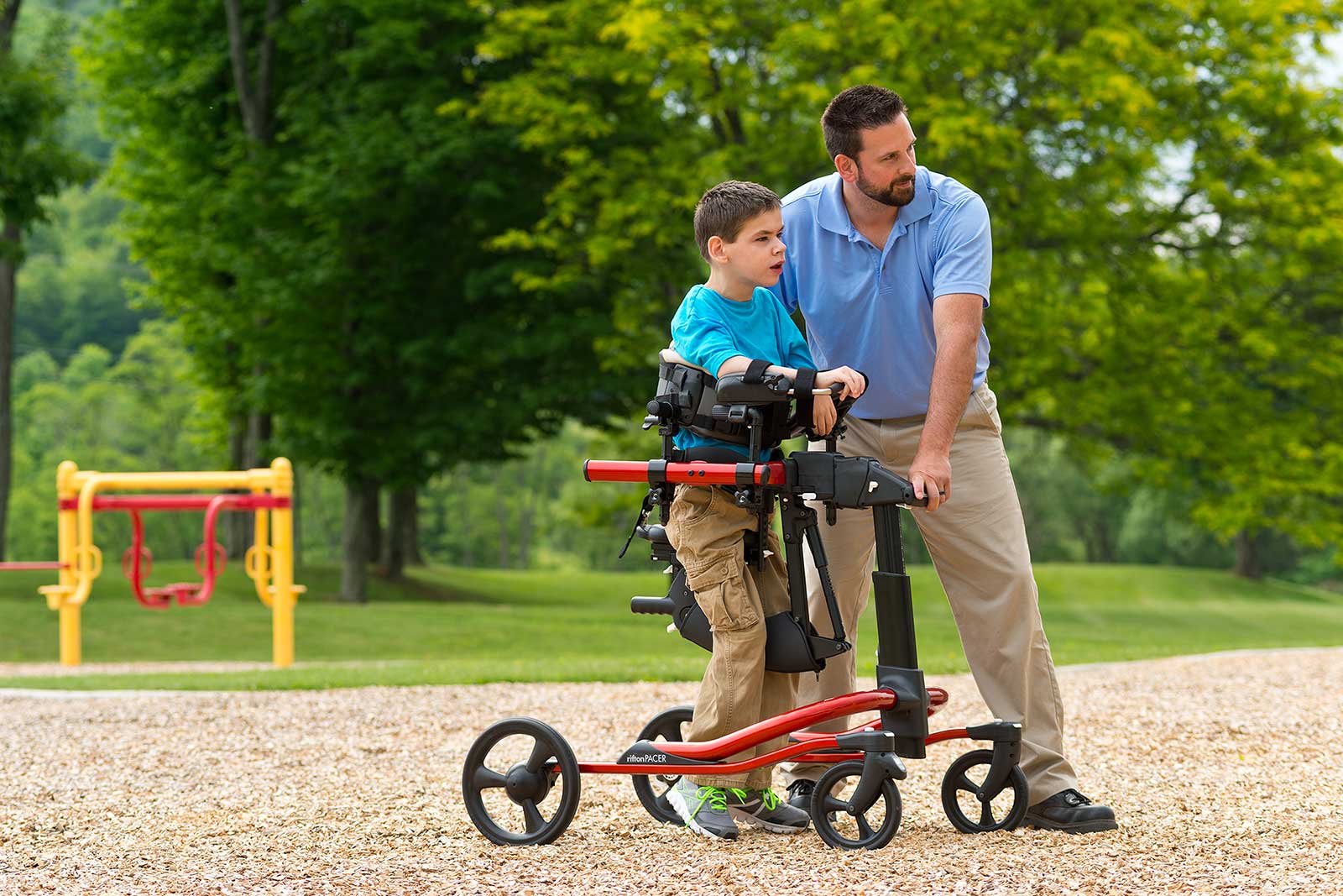 Boy with dad in Rifton Pacer gait trainer