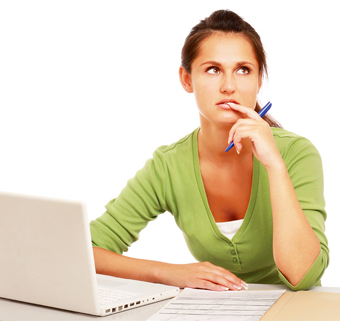 young woman working on a laptop, frowning