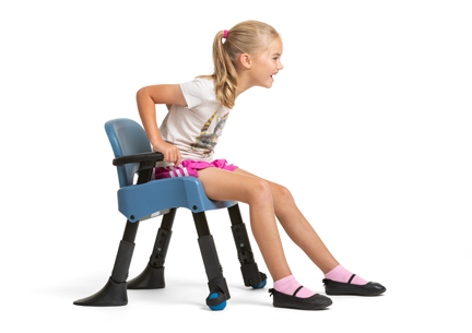 A girl sits on a Rifton Compass Chair and smiles.