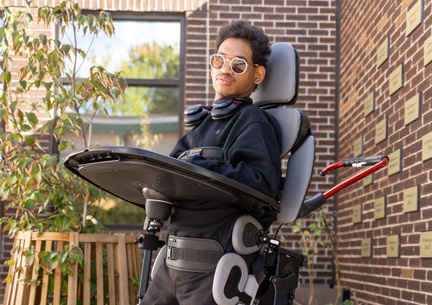 A young man standing in a Size 3 Rifton Stander