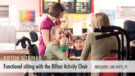 A child sits happily in a Rifton Activity Chair at a table surrounded by classmates and teachers.